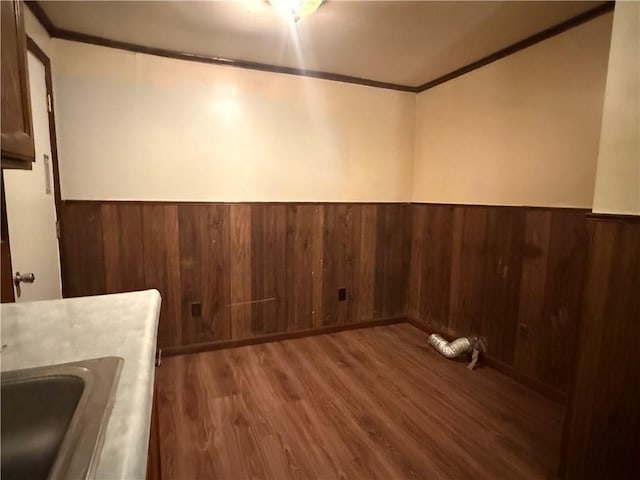 303 Bell St, Richmond, MO 64085 - unfurnished dining area with ornamental molding, a wainscoted wall, wood finished floors, and wood walls