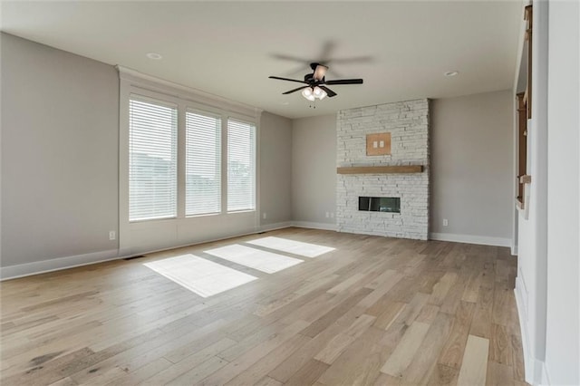 16941 S Brentwood St, Olathe, KS 66062 - unfurnished living room with ceiling fan, light wood finished floors, and a stone fireplace