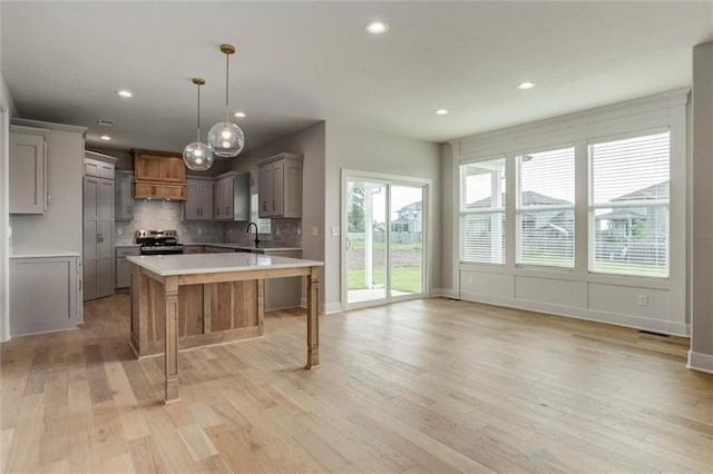 16941 S Brentwood St, Olathe, KS 66062 - kitchen with stainless steel range with electric cooktop, light countertops, gray cabinets, light wood-style floors, and a center island