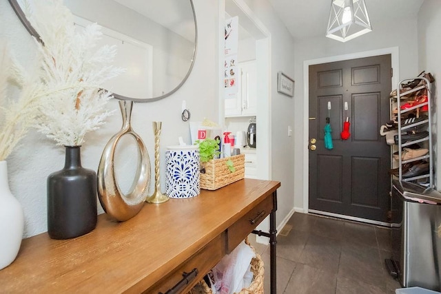 7921 Yecker St, Kansas City, KS 66102 - foyer with dark tile patterned floors and baseboards