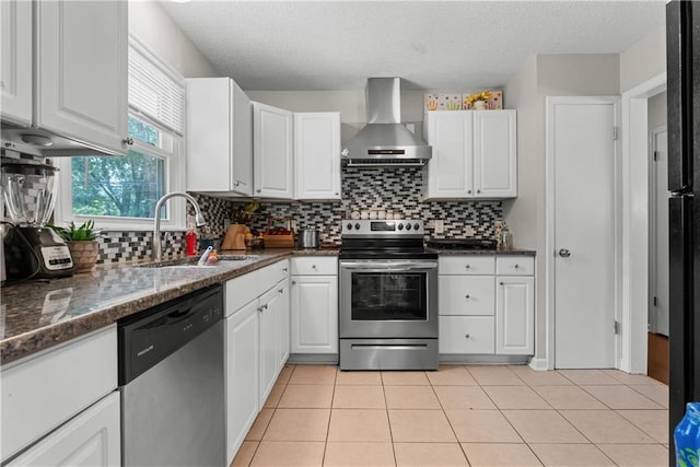 13211 Craig Ave, Grandview, MO 64030 - kitchen featuring stainless steel appliances, wall chimney range hood, white cabinets, a textured ceiling, and backsplash