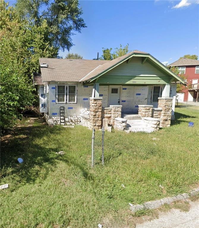 2222 Hickam Dr, Kansas City, KS 66104 - view of front facade with a front yard, a porch, and roof with shingles