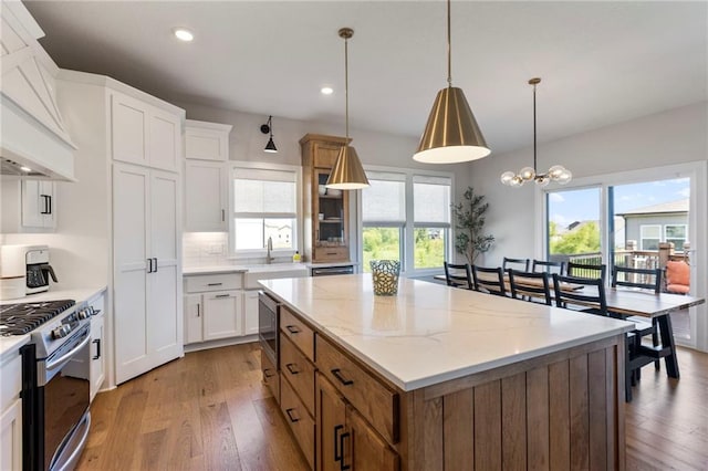 19013 W 188th Ter, Spring Hill, KS 66083 - kitchen featuring appliances with stainless steel finishes, premium range hood, a kitchen island, light wood-style flooring, and recessed lighting