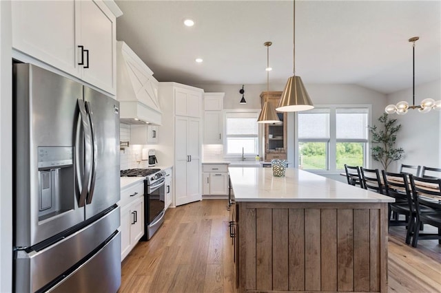19013 W 188th Ter, Spring Hill, KS 66083 - kitchen featuring stainless steel appliances, custom range hood, light wood-type flooring, backsplash, and light countertops