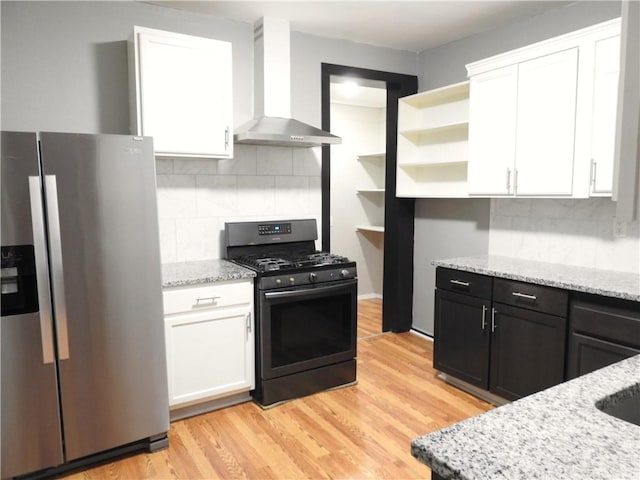3009 Montgall Ave, Kansas City, MO 64128 - kitchen featuring stainless steel refrigerator with ice dispenser, wall chimney exhaust hood, black gas range, white cabinetry, and backsplash
