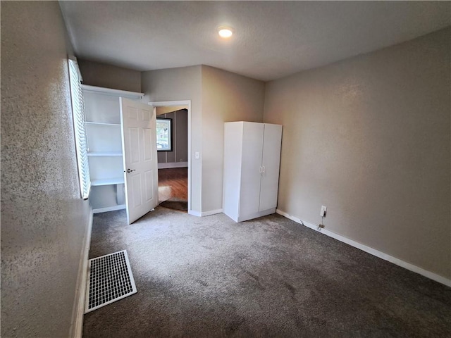 3009 Montgall Ave, Kansas City, MO 64128 - unfurnished bedroom featuring carpet flooring and a textured wall