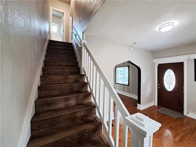3009 Montgall Ave, Kansas City, MO 64128 - entryway with stairway, wood finished floors, plenty of natural light, and a textured ceiling