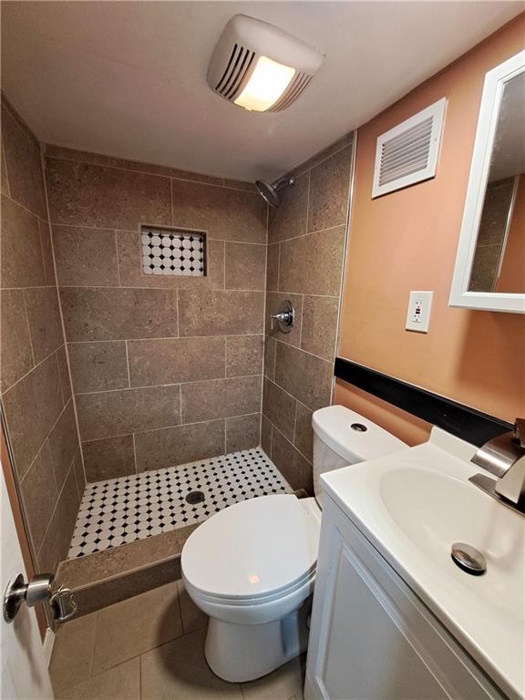 3009 Montgall Ave, Kansas City, MO 64128 - full bath with a tile shower, vanity, and tile patterned floors