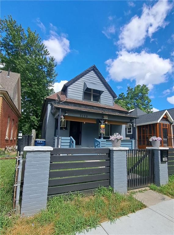 3009 Montgall Ave, Kansas City, MO 64128 - view of front of property featuring a fenced front yard, a gate, and a porch