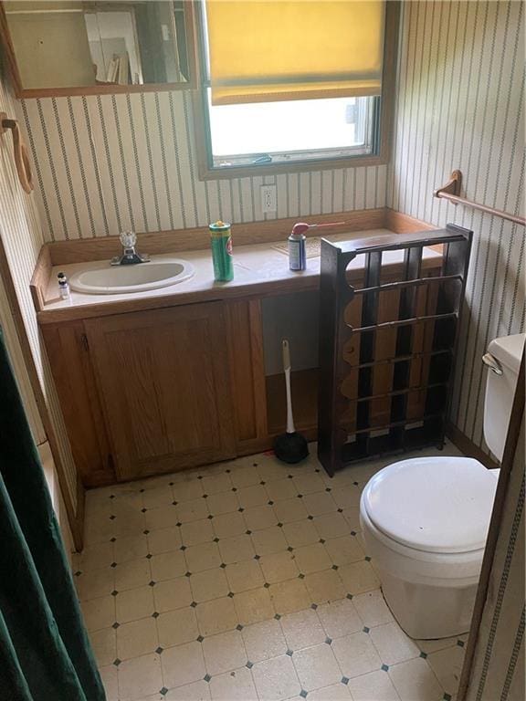 101 E Vine St, Arcadia, KS 66711 - half bath with wallpapered walls, vanity, and tile patterned floors