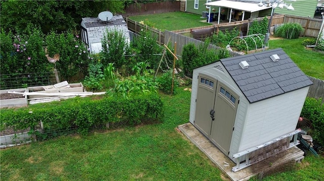 1736 Brook St, Lawrence, KS 66044 - fenced backyard featuring a storage unit and a vegetable garden