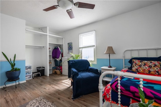 1736 Brook St, Lawrence, KS 66044 - bedroom with wood finished floors, a closet, a textured ceiling, and ceiling fan