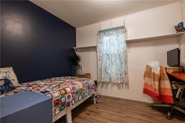 1736 Brook St, Lawrence, KS 66044 - bedroom featuring wood finished floors and a textured ceiling
