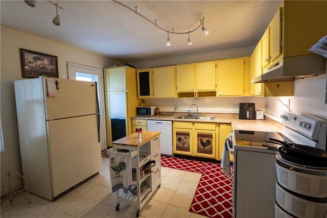 1736 Brook St, Lawrence, KS 66044 - kitchen featuring white appliances, rail lighting, cream cabinetry, light countertops, and under cabinet range hood