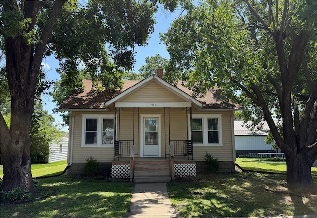 411 S Bismark, Concordia, MO 64020 - bungalow-style home with a chimney and a front lawn