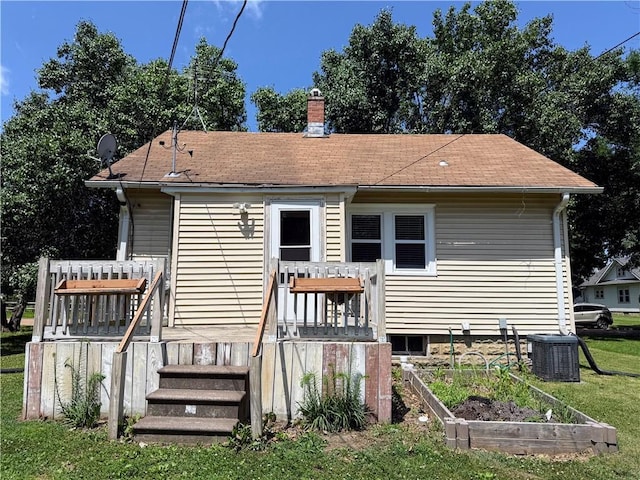 411 S Bismark, Concordia, MO 64020 - rear view of house with a wooden deck, a vegetable garden, a chimney, a lawn, and roof with shingles