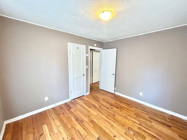 5046 Glenside Ct, Kansas City, MO 64129 - unfurnished bedroom featuring light wood finished floors and a textured ceiling