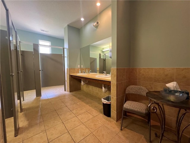 11681 S Roundtree St, Olathe, KS 66061 - full bathroom featuring a stall shower, tile patterned floors, tile walls, a wainscoted wall, and recessed lighting