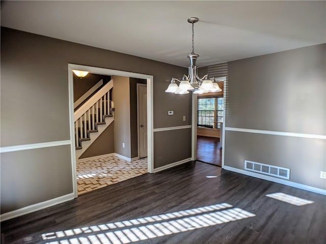 10122 Earnshaw St, Lenexa, KS 66215 - empty room featuring a chandelier, wood finished floors, and stairs