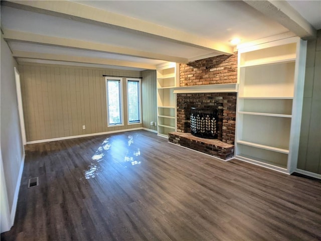 10122 Earnshaw St, Lenexa, KS 66215 - unfurnished living room featuring beam ceiling, wood finished floors, a brick fireplace, and wooden walls