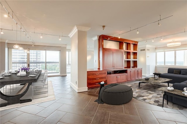 2510 Grand Blvd Unit 2502-03, Kansas City, MO 64108 - living area with rail lighting, ornamental molding, healthy amount of natural light, and tile patterned flooring