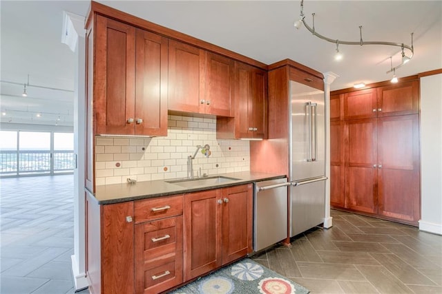 2510 Grand Blvd Unit 2502-03, Kansas City, MO 64108 - kitchen with track lighting, dishwasher, dark countertops, tasteful backsplash, and brown cabinetry