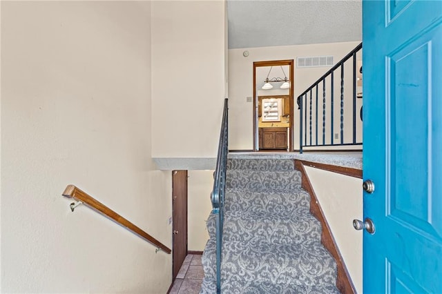 19308 E 18th St N, Independence, MO 64058 - stairway featuring tile patterned floors and a textured ceiling