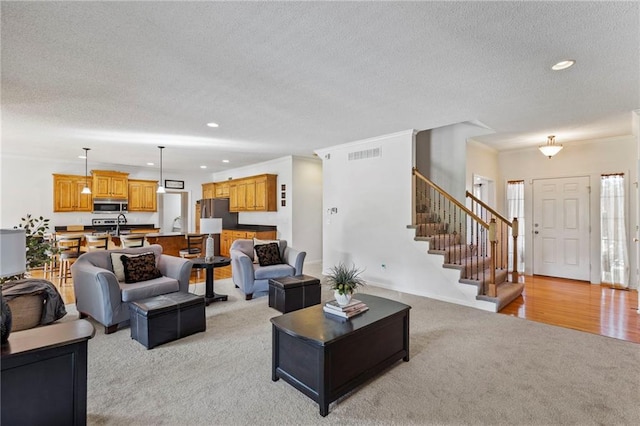 2712 SW Carlton Dr, Lees Summit, MO 64082 - living room with light colored carpet, recessed lighting, a textured ceiling, and stairs