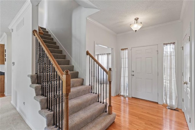2712 SW Carlton Dr, Lees Summit, MO 64082 - foyer entrance with stairway, ornamental molding, a textured ceiling, and light wood-style flooring