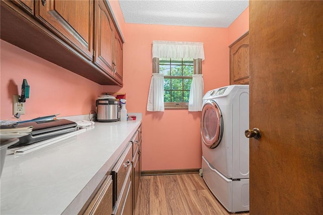 21830 155th St, Basehor, KS 66007 - laundry area featuring cabinet space, light wood-style flooring, washer / clothes dryer, and a textured ceiling