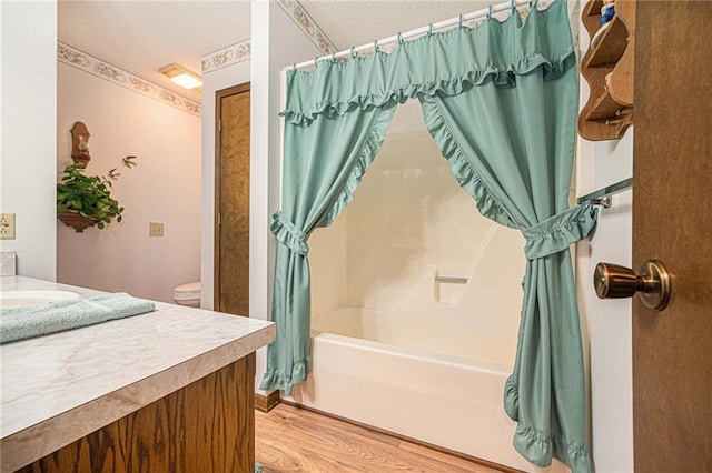 21830 155th St, Basehor, KS 66007 - full bathroom featuring vanity, shower / bathtub combination with curtain, a textured ceiling, and wood finished floors