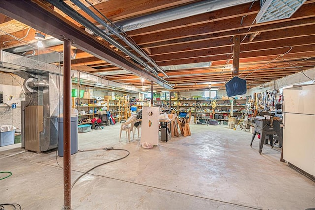 21830 155th St, Basehor, KS 66007 - unfinished basement with freestanding refrigerator, a workshop area, and heating unit