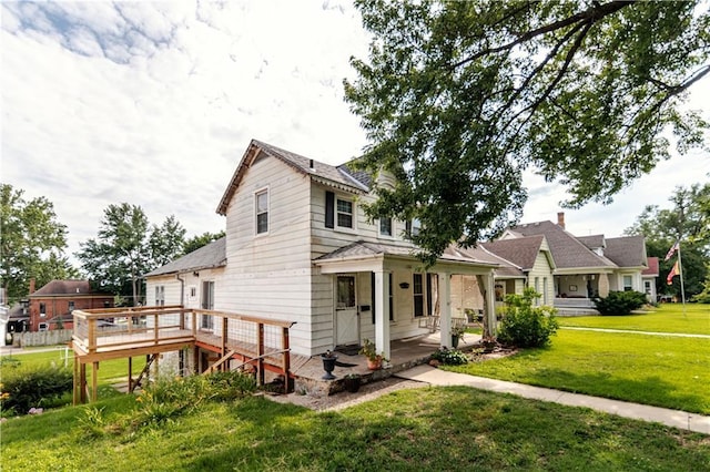 1134 Atchison St, Atchison, KS 66002 - view of front of property featuring a front yard, covered porch, and a deck