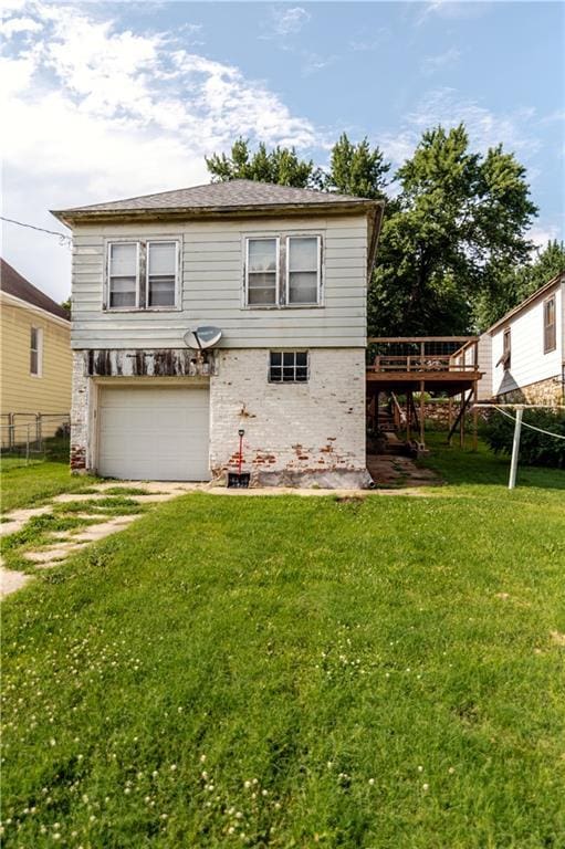 1134 Atchison St, Atchison, KS 66002 - rear view of property featuring a wooden deck, an attached garage, brick siding, and driveway