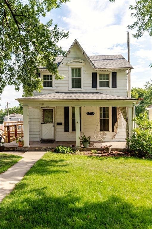 1134 Atchison St, Atchison, KS 66002 - view of front of property featuring a porch, a front lawn, and a shingled roof