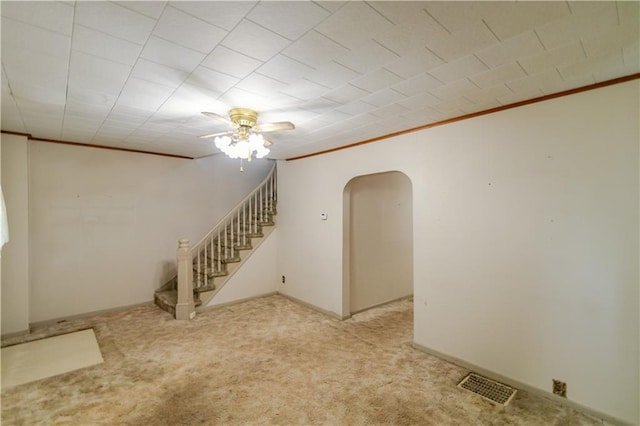1134 Atchison St, Atchison, KS 66002 - unfurnished room with arched walkways, crown molding, a ceiling fan, light carpet, and stairway