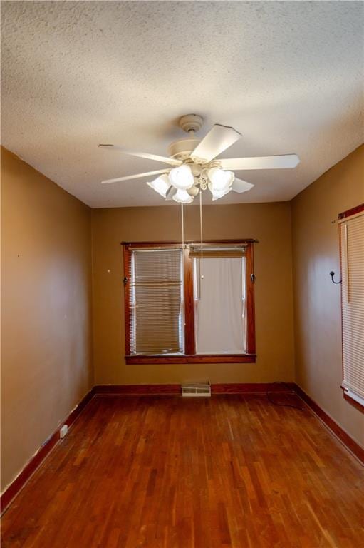 1134 Atchison St, Atchison, KS 66002 - spare room with wood finished floors, a ceiling fan, and a textured ceiling