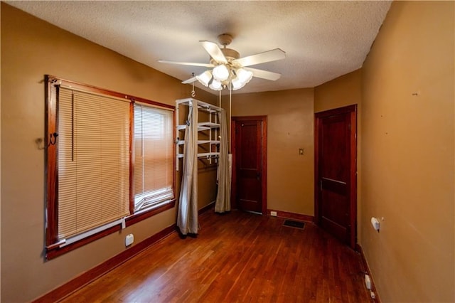 1134 Atchison St, Atchison, KS 66002 - unfurnished bedroom with wood finished floors, a textured ceiling, and a ceiling fan