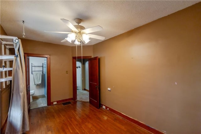1134 Atchison St, Atchison, KS 66002 - unfurnished bedroom with wood finished floors, ceiling fan, and ensuite bathroom
