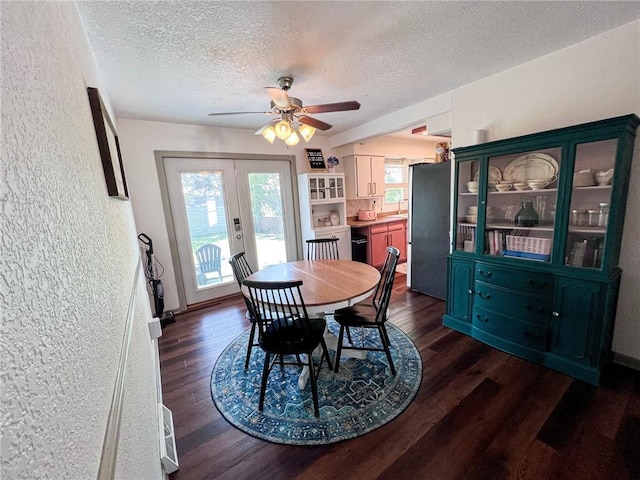 701 N Godfrey St, Cameron, MO 64429 - dining space with a textured ceiling, dark wood-style flooring, ceiling fan, a textured wall, and french doors