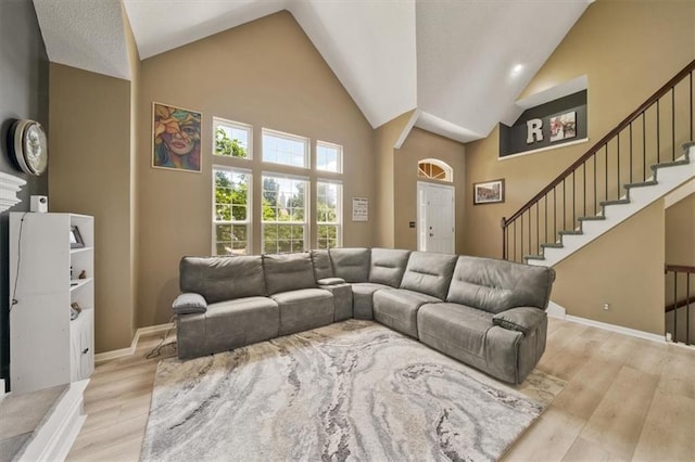 16122 W 157th St, Olathe, KS 66062 - living area featuring high vaulted ceiling, wood finished floors, and stairs