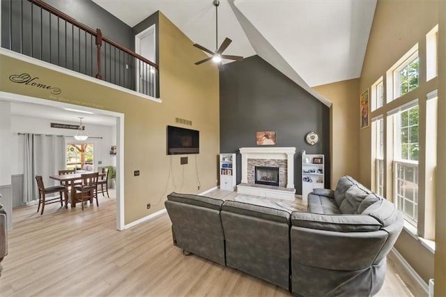 16122 W 157th St, Olathe, KS 66062 - living area with high vaulted ceiling, a ceiling fan, a fireplace, and wood finished floors