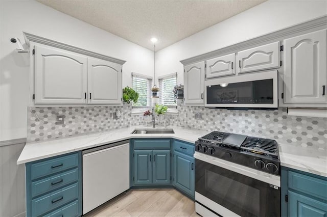 16122 W 157th St, Olathe, KS 66062 - kitchen featuring dishwashing machine, gas stove, white microwave, blue cabinets, and a textured ceiling