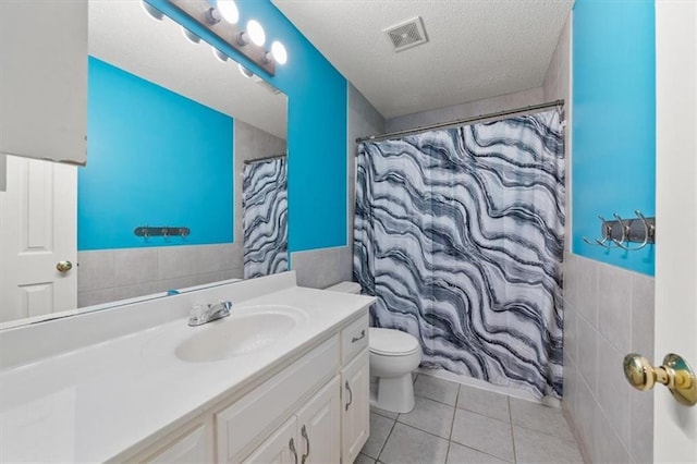 16122 W 157th St, Olathe, KS 66062 - full bathroom featuring vanity, a wainscoted wall, tile walls, tile patterned floors, and a textured ceiling