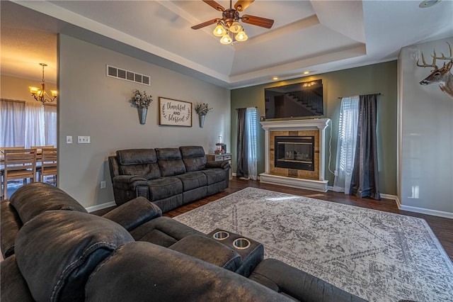 61 SW 446th Rd, Clinton, MO 64735 - living area featuring a chandelier, ceiling fan, wood finished floors, a raised ceiling, and a tiled fireplace