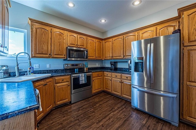 61 SW 446th Rd, Clinton, MO 64735 - kitchen featuring appliances with stainless steel finishes, brown cabinetry, dark wood-style flooring, dark countertops, and recessed lighting