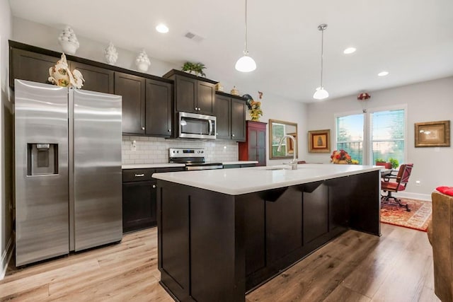 2214 SW 9th St, Blue Springs, MO 64014 - kitchen featuring appliances with stainless steel finishes, light countertops, light wood-style floors, an island with sink, and recessed lighting