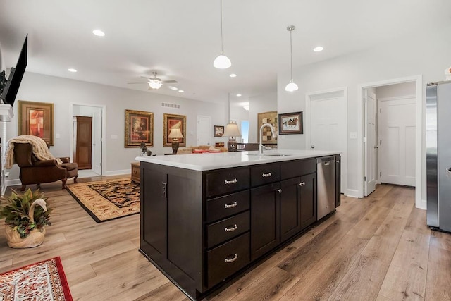 2214 SW 9th St, Blue Springs, MO 64014 - kitchen featuring appliances with stainless steel finishes, open floor plan, ceiling fan, light countertops, and light wood-style flooring