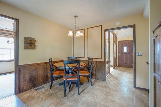 16327 W Locust St, Olathe, KS 66062 - dining room with a wainscoted wall, a chandelier, and a textured ceiling