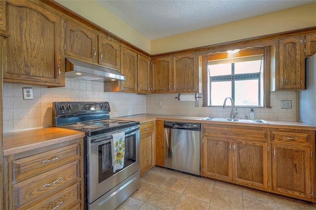 16327 W Locust St, Olathe, KS 66062 - kitchen with appliances with stainless steel finishes, under cabinet range hood, brown cabinets, light countertops, and a textured ceiling